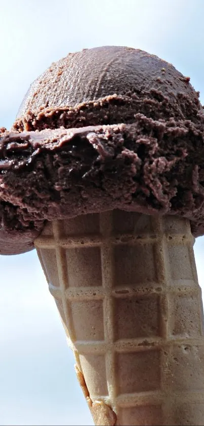 Chocolate ice cream cone under blue sky