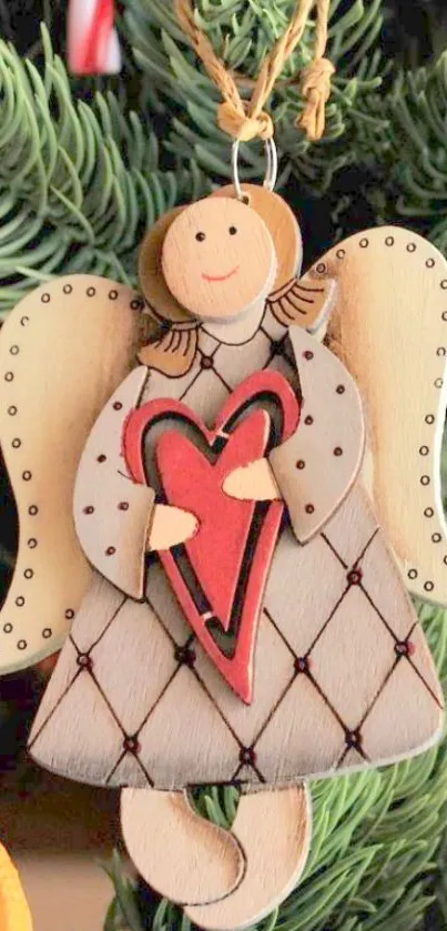 Charming Christmas angel ornament with heart, set against festive greenery.