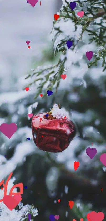 Red Christmas ornament on snowy evergreen with heart shapes.