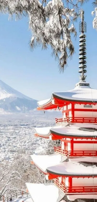 Snowy pagoda with Mount Fuji in the background under a clear sky.