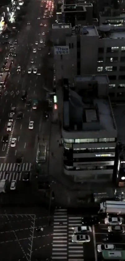 Aerial view of city street at night with vibrant lights and traffic.