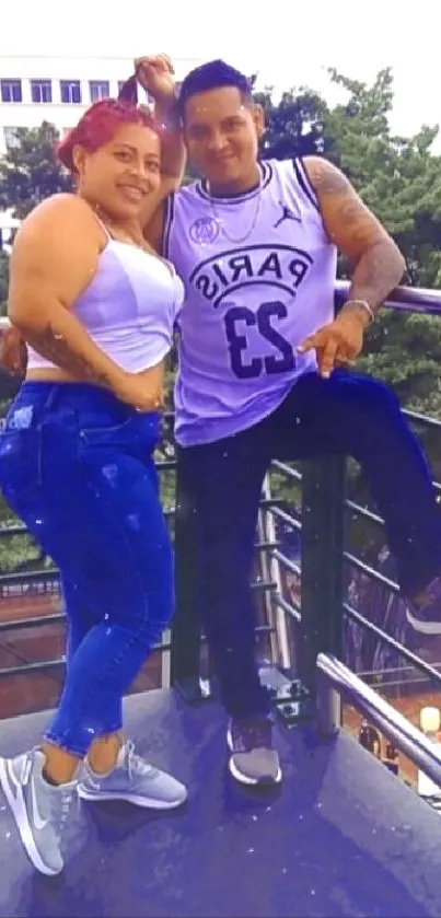 Casual couple posing on a city balcony.