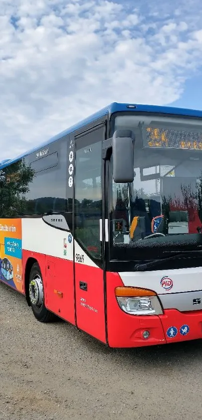 City bus on a sunny day with blue sky and greenery.