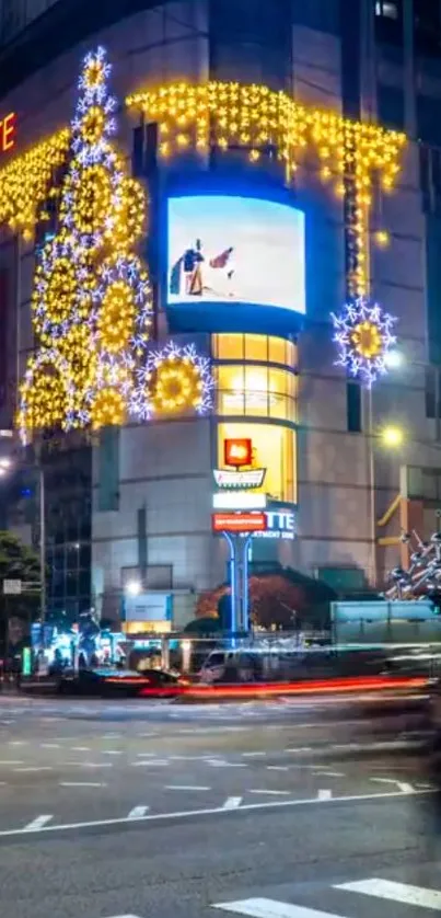 Night view of city building with festive lights and traffic.