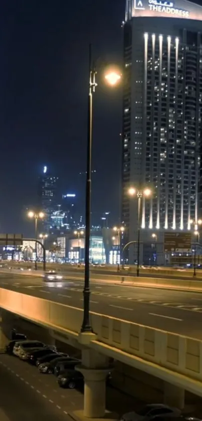 City street illuminated by night lights with skyscrapers in the background.