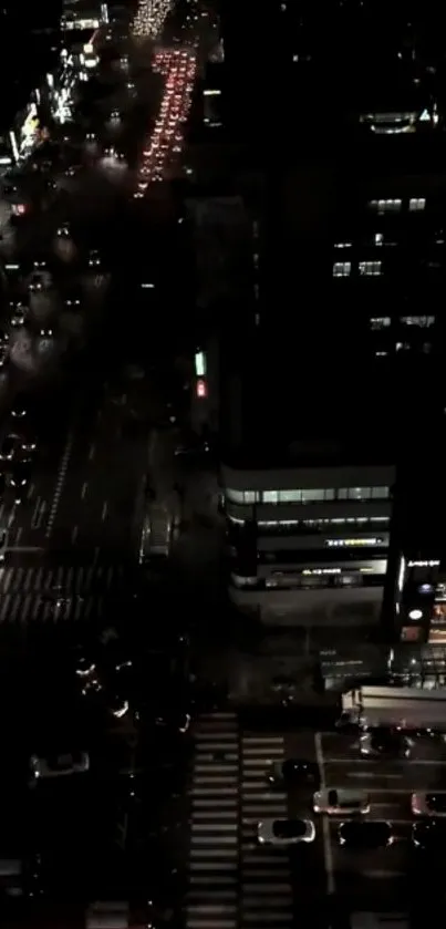 Aerial view of a city street at night with bright lights and traffic.