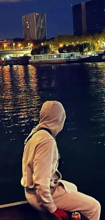 Person gazing at city lights across a reflective river at night.