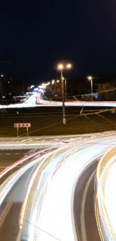 Night city traffic with vibrant light trails under a dark blue sky.