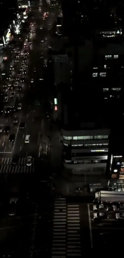 Aerial view of a city street at night with busy traffic and vibrant lights.