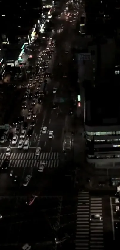 Aerial view of city street at night with busy traffic and streetlights illuminating the scene.