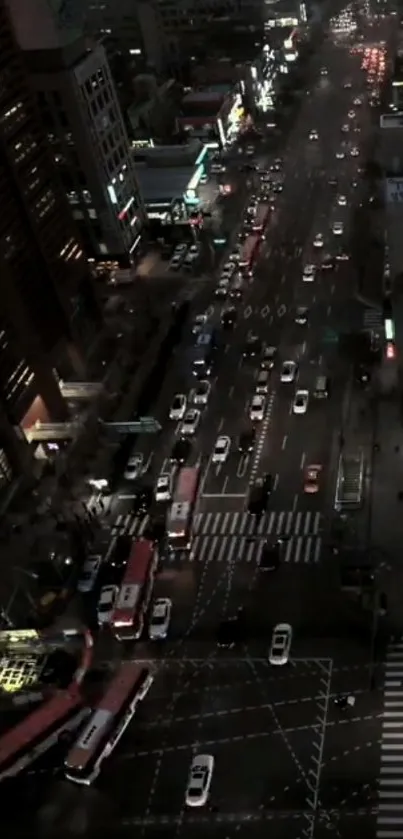 Aerial view of city street with night traffic and glowing lights.