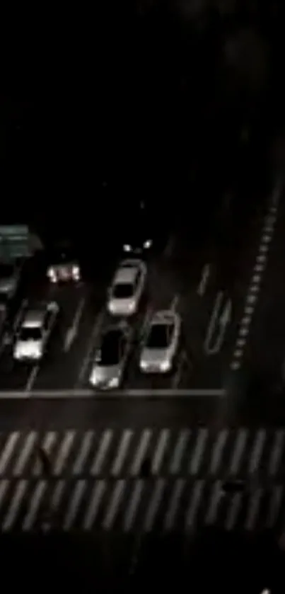 City night traffic with cars on an illuminated intersection.