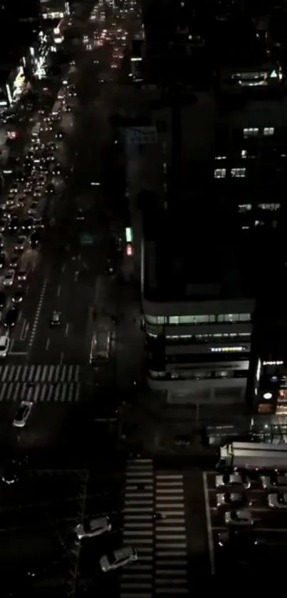 Aerial view of a city street at night with glowing lights and busy traffic.