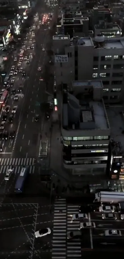 Aerial view of city streets at night with illuminated buildings.