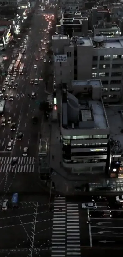 Night cityscape with busy streets and illuminated buildings viewed from above.