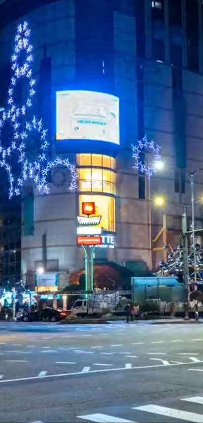 Illuminated city street at night with vibrant building lights.