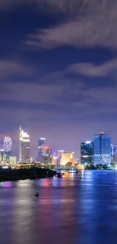 Vibrant city skyline at night with lights reflecting on the river.