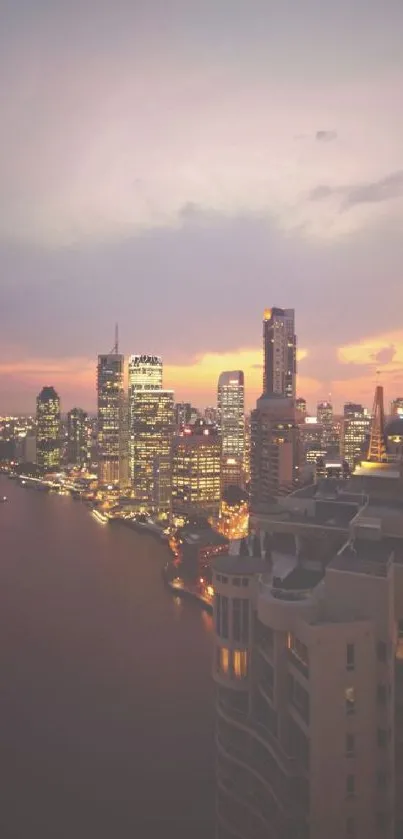 Aerial view of city skyline at sunset with colorful sky.