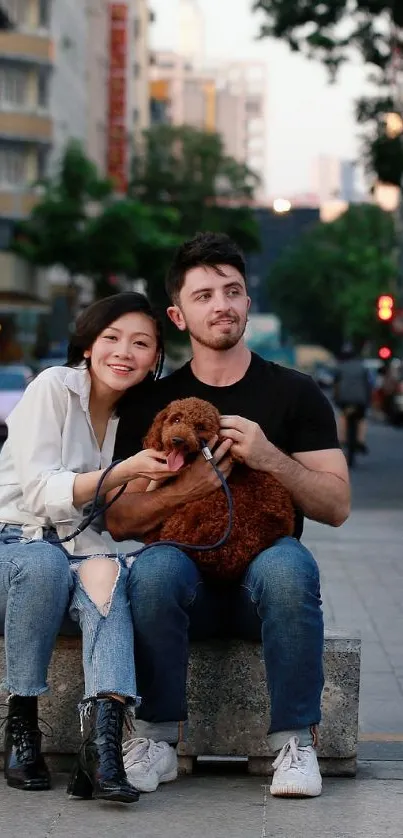 Couple with dog sitting on a city street in the evening.