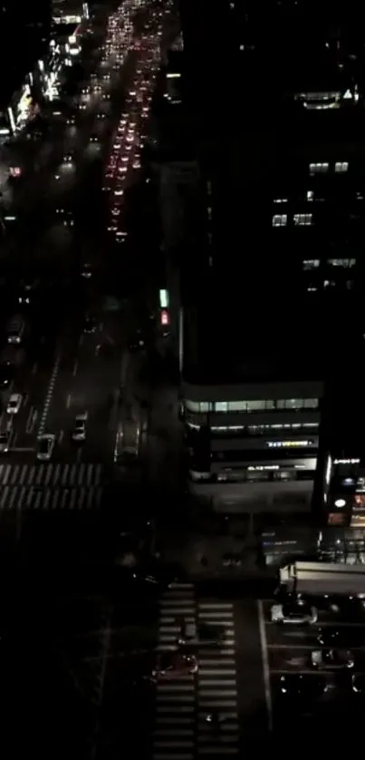 Aerial view of a city street at night, illuminated by urban lights.