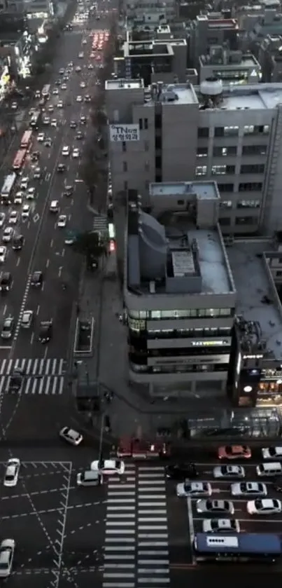 Aerial view of a bustling city street with cars and skyscrapers at dusk.