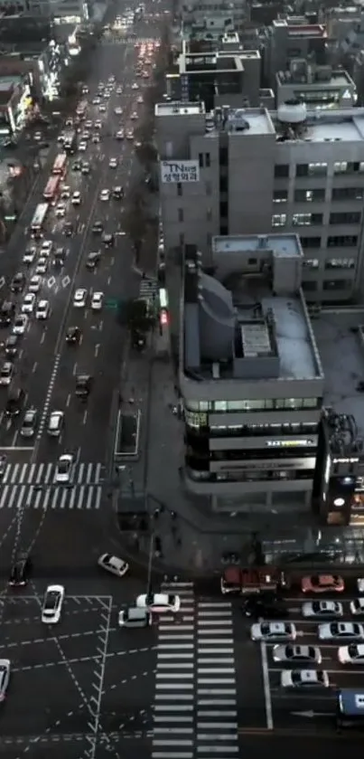 Aerial view of city streets at dusk with traffic and lit buildings.