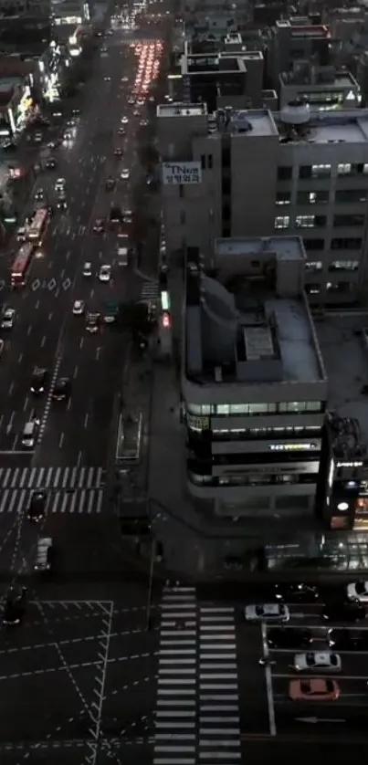 Aerial view of a cityscape at night with busy streets and illuminated buildings.