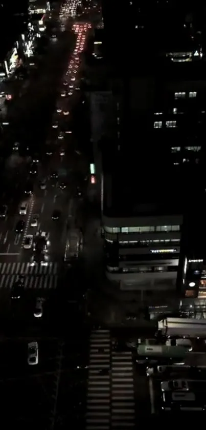 Nighttime city street view with traffic lights and buildings.