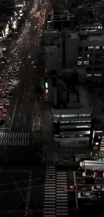 Aerial view of city streets at night with bustling traffic and illuminated buildings.