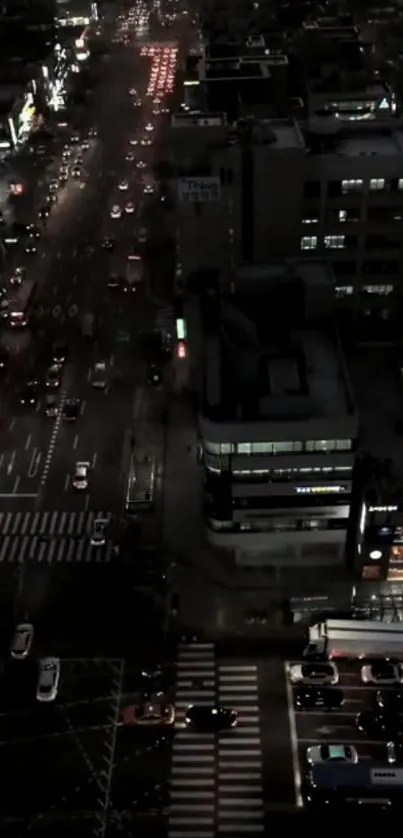 Aerial view of a city street at night with glowing traffic lights.