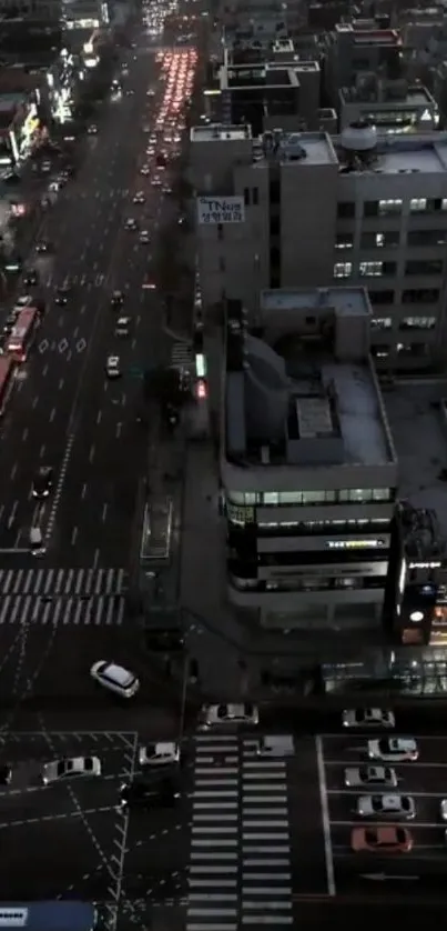 Aerial view of city at night with streets and buildings illuminated.