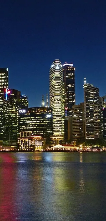 A city skyline at night with reflections on water.