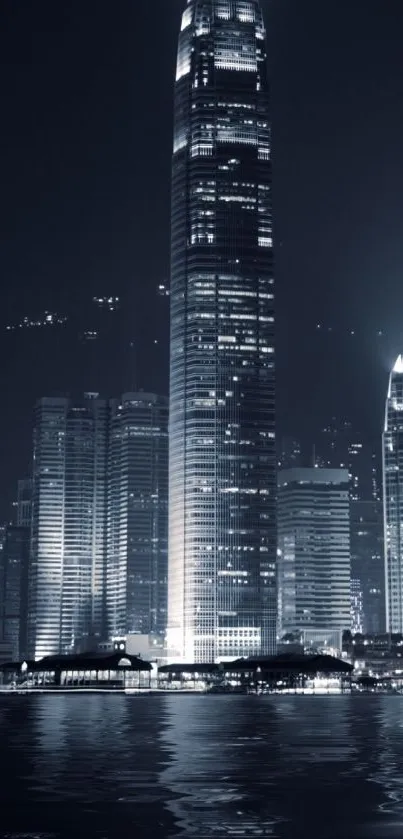 Mobile wallpaper of skyscraper at night with city lights and water reflections.