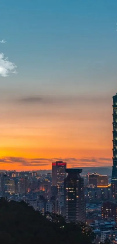 City skyline at sunset with a tall, illuminated tower and glowing sky.