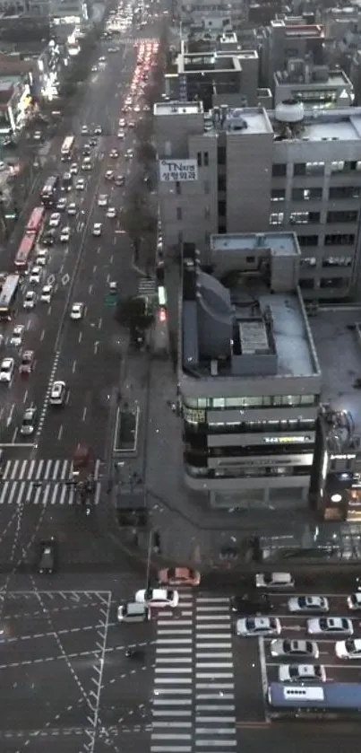 Evening cityscape with buildings and streets, captured from above in gray tones.