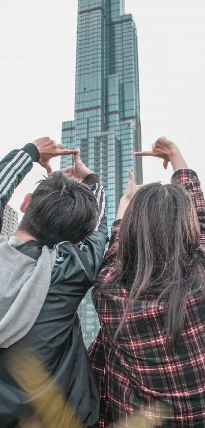 Couple sitting in grass, skyscrapers in view.