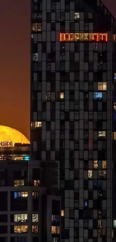 Full moon rising behind city skyscrapers at night.