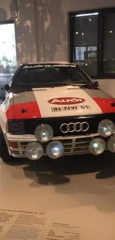 Classic Audi rally car with red and white livery in museum.