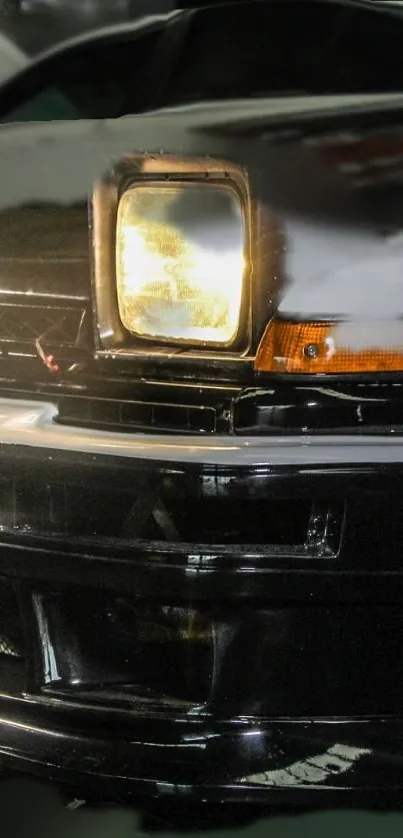 Close-up of a black classic car's headlight with a sleek design.