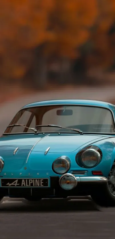 Blue vintage sports car with autumn backdrop.