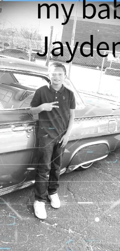 Black and white image of a boy with a classic car.