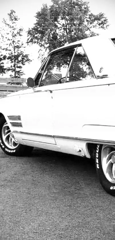 Classic black and white photo of a vintage car parked outdoors.