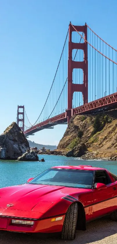 Red classic car by Golden Gate Bridge under blue sky.