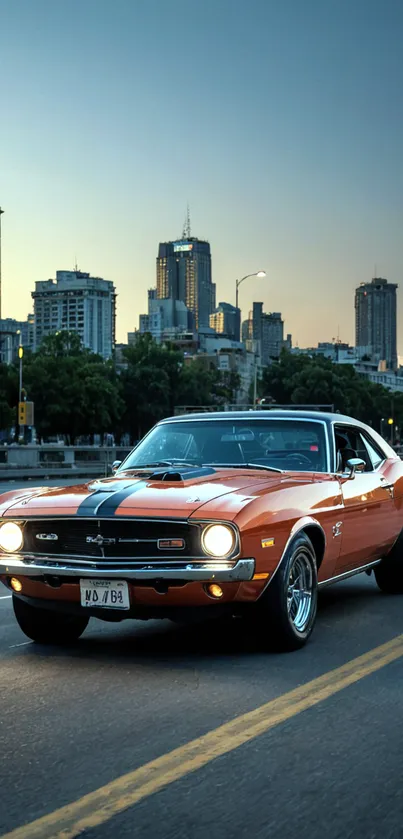 Vintage orange car driving through city at dusk, with illuminated skyline.