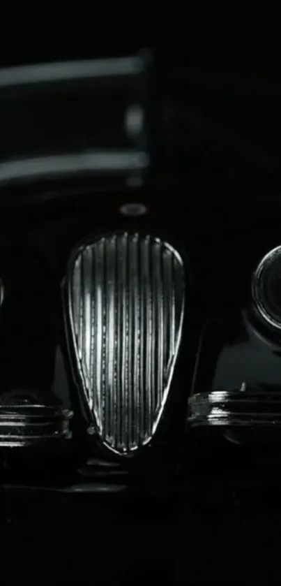 Front view of a classic car in black, creating a sleek and mysterious wallpaper.