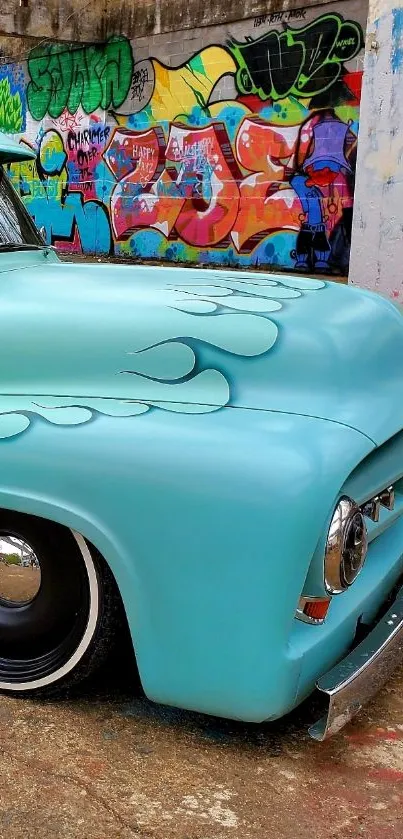 Teal classic car with urban graffiti background.