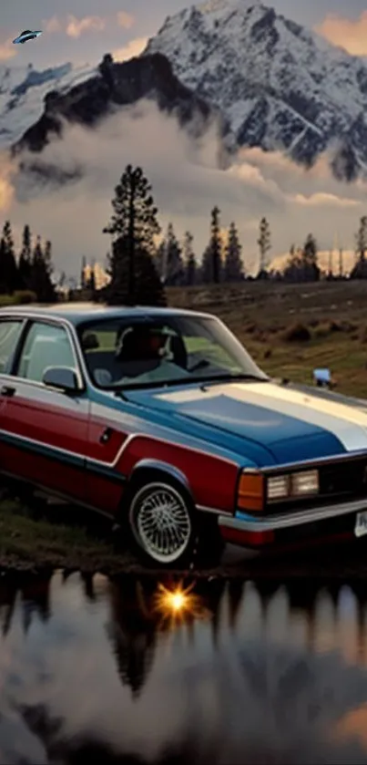 Classic car parked by a lake with snowy mountains in the background.