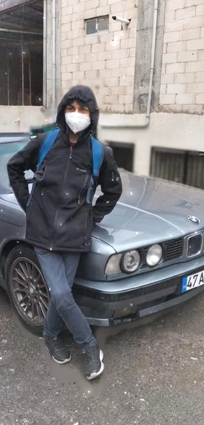 Person in casual attire with classic BMW in urban backdrop.