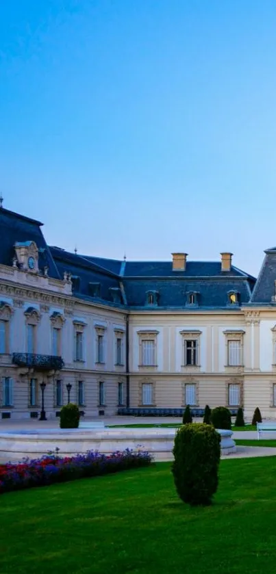 Elegant European palace with lush garden and blue sky background.