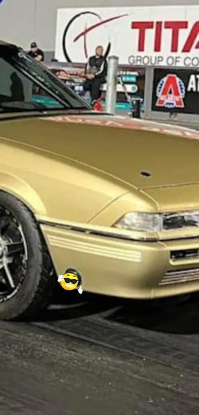 A sleek classic gold car with black wheels on a racing track.